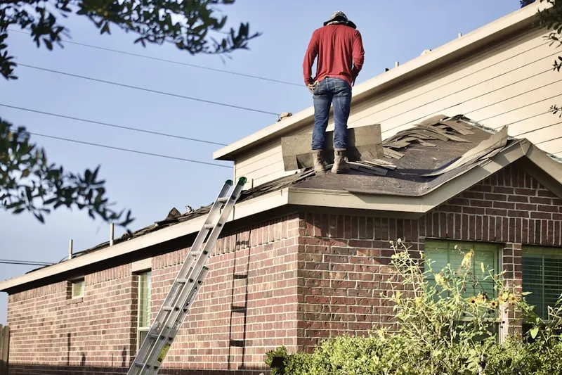 Professional roofer working on a residential roof in Macton
